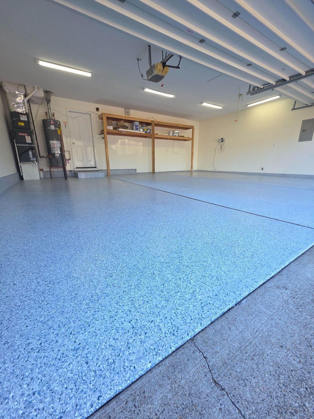 Finished two-car garage with a pale blue and grey flake floor running wall to wall under white walls
