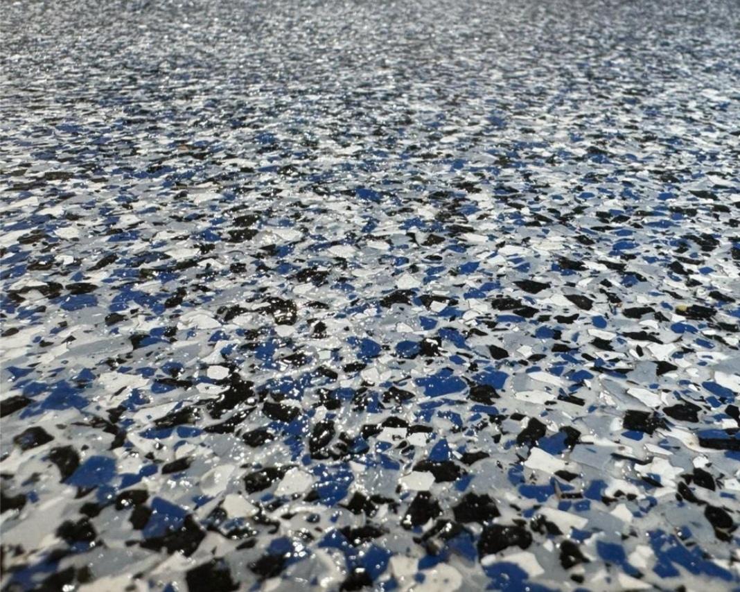 Close detail of blue, white, black and grey vinyl flake locked under a clear topcoat