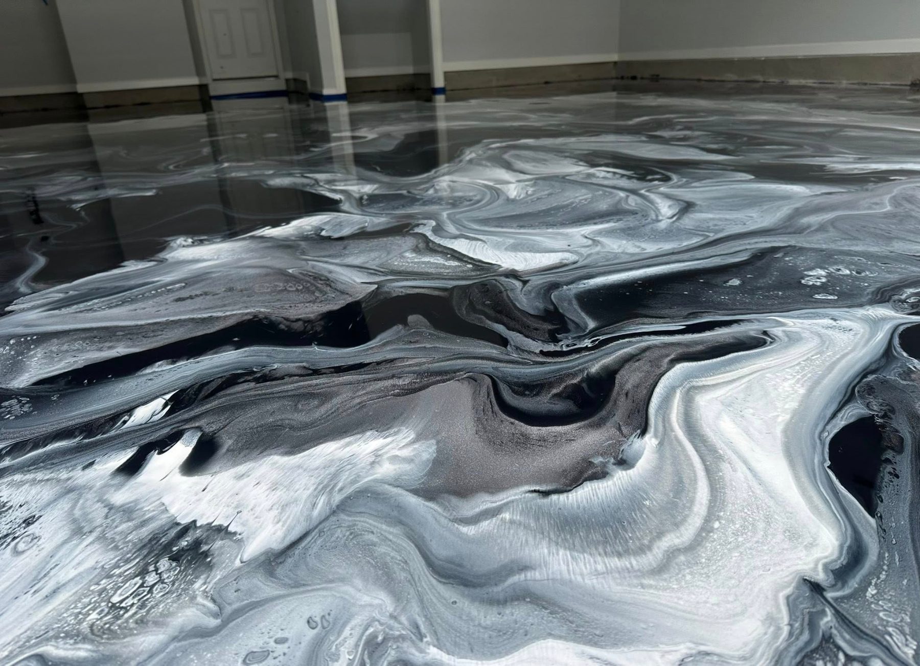 Metallic epoxy floor with deep blue and pearl-white marbling